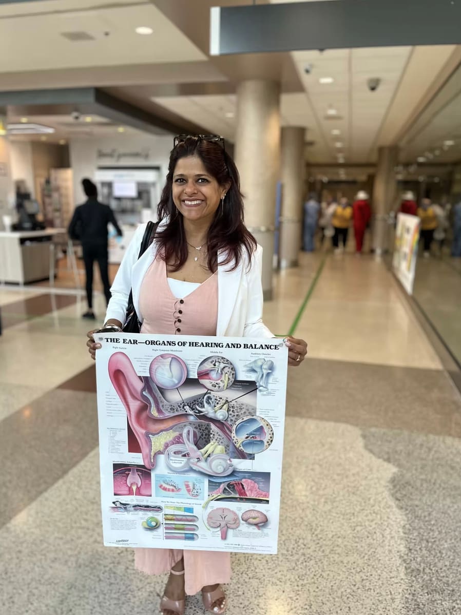 Roopali Neemuchwala holding an inner ear anatomy chart